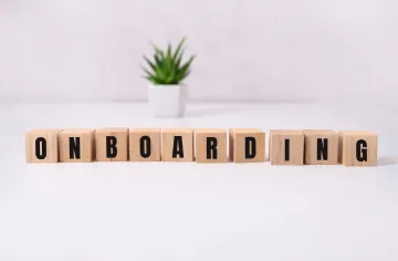 Wooden blocks spelling out onboarding with a plant behind 